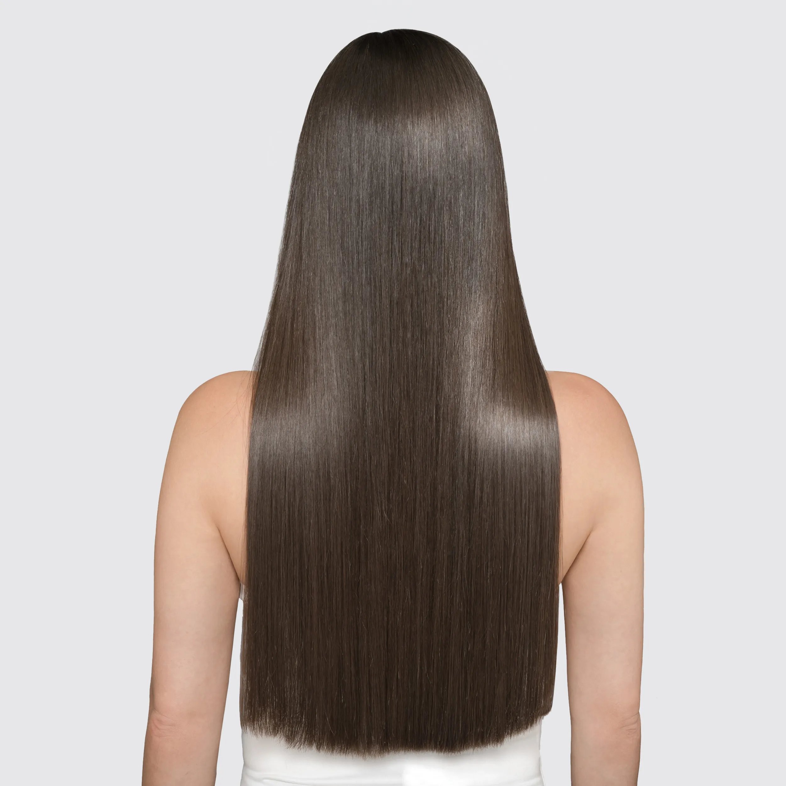 Model with long dark hair faces away from the camera. Hair looks shiny and healthy after using Wella Professionals Oil Reflections.