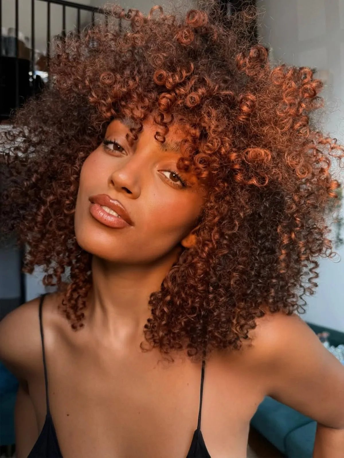 Model with full, bouncy, copper bronze curls.