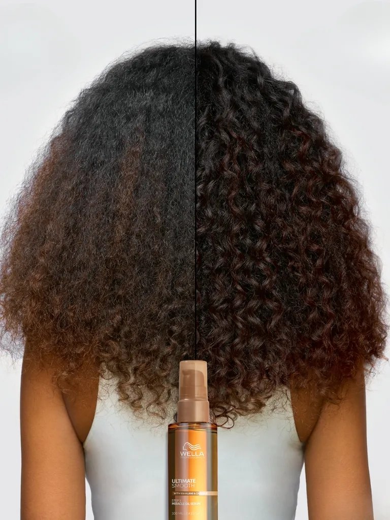 Before and after showing model’s long, brown, curly hair looking more defined after using ULTIMATE SMOOTH.
