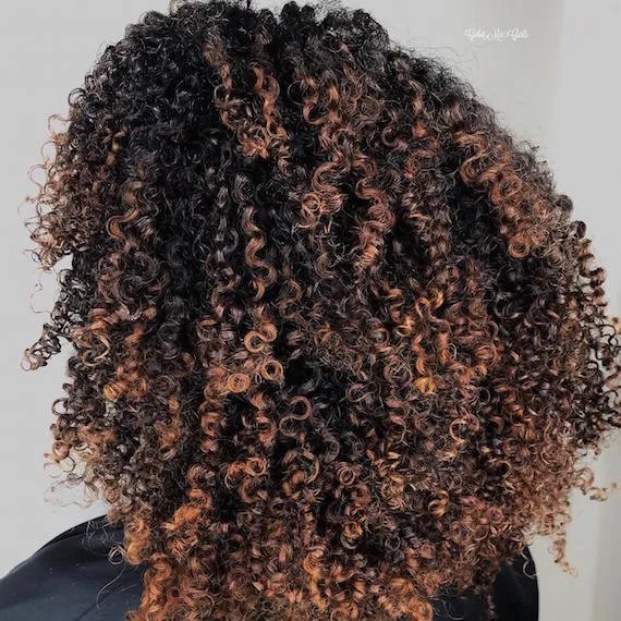 Photo of woman with dark brown, curly hair, created using Wella Professionals.