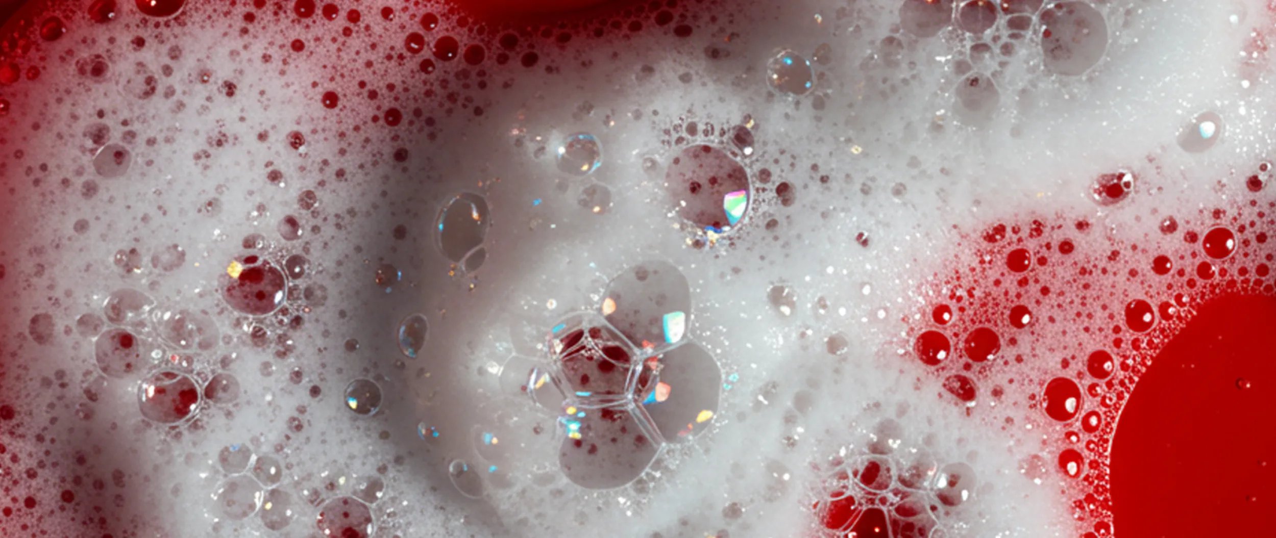 Foamy bubbles on a red surface.