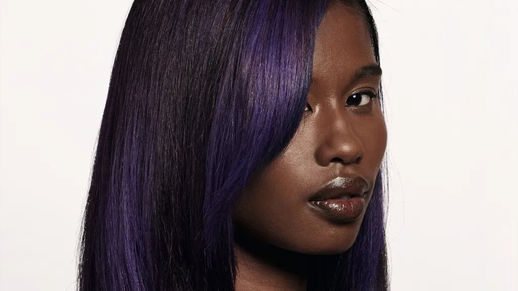 Dark brown hair featuring bold violet highlights.
