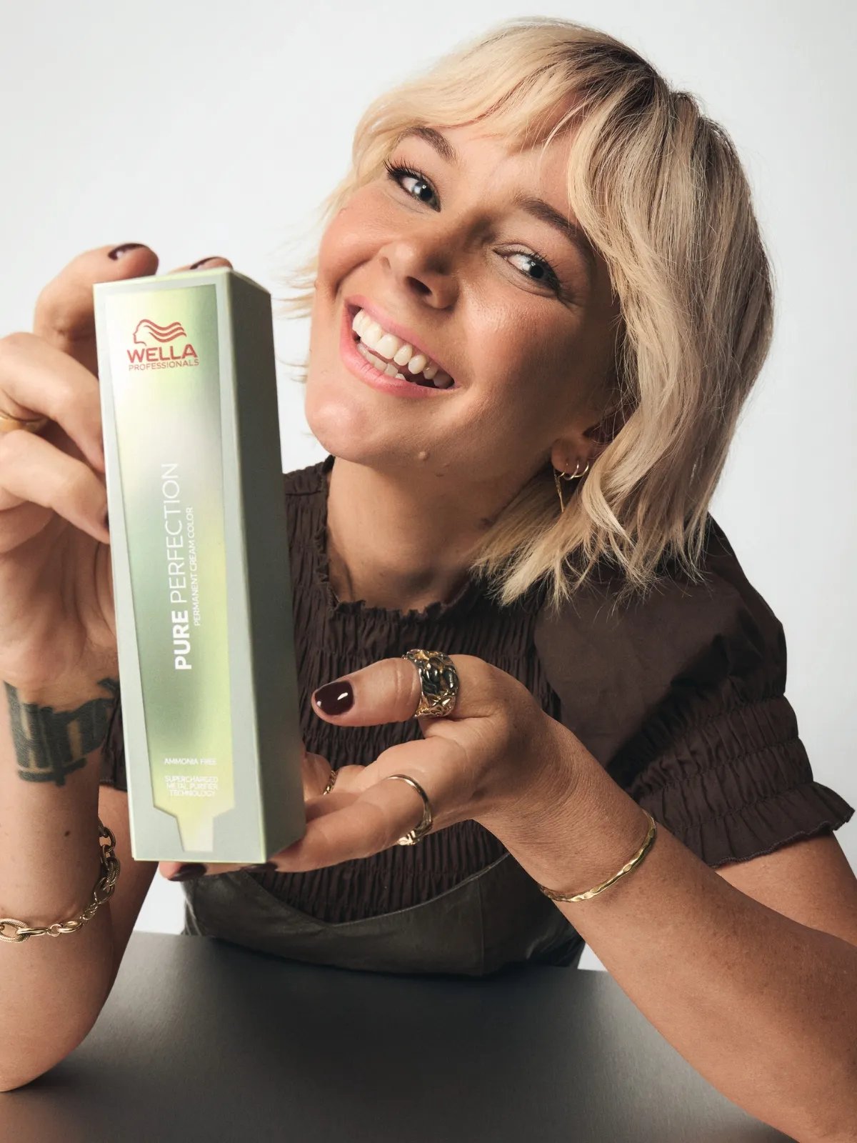 Wella Professionals Brand Ambassador Briana Cisneros holds a box of Pure Perfection hair color.
