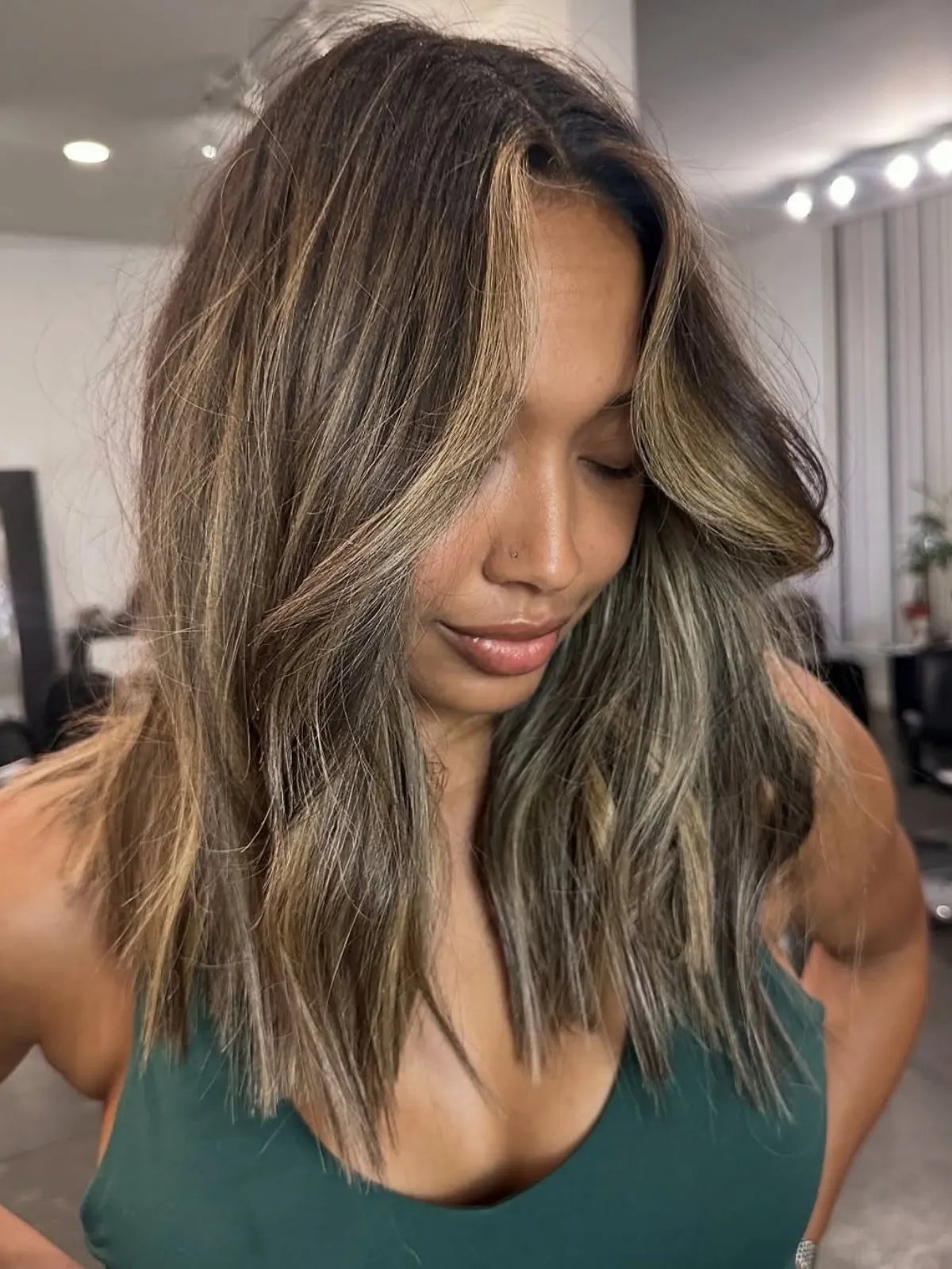Model with medium-length, straight, brunette hair, featuring brown-blonde highlights.