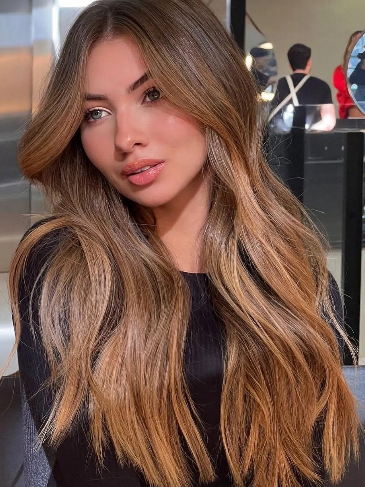 Light chocolate brown hair color with warm, sun-dappled tones and a bronde effect.