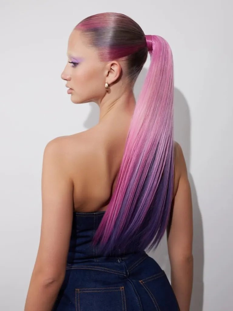 Model with ultra-long, pink and purple hair tied back in a sleek pony.