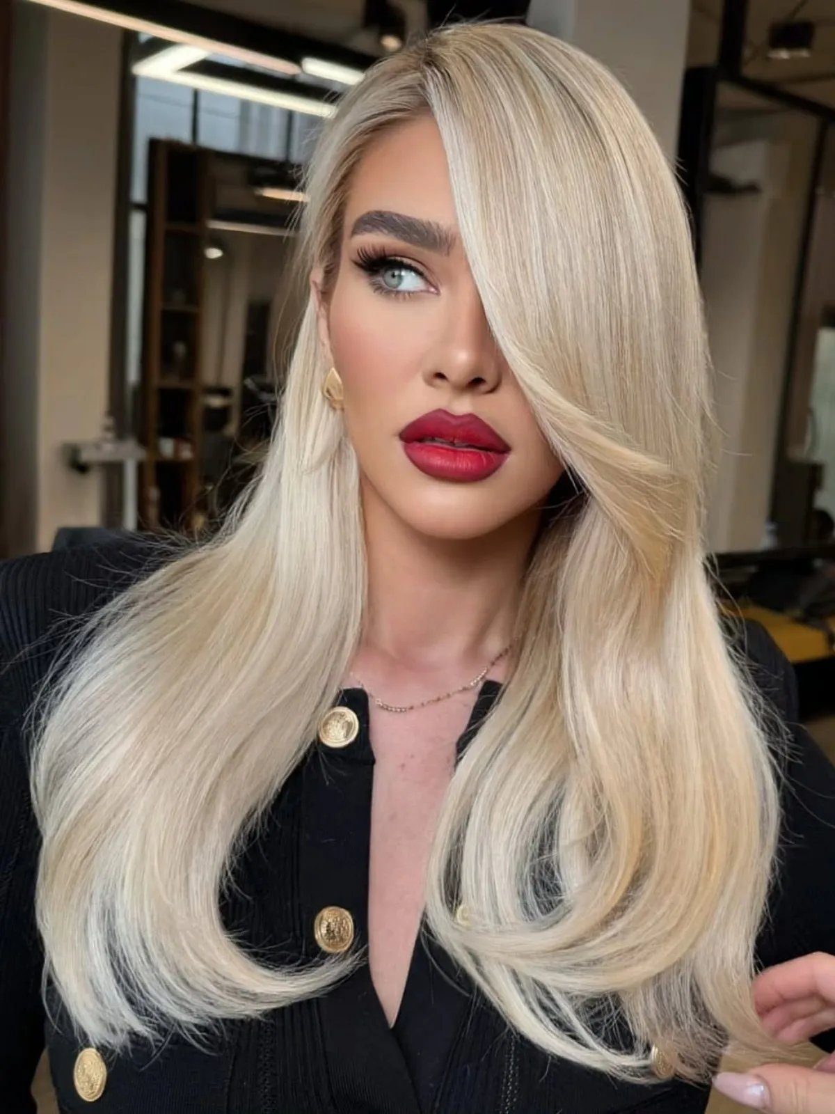 Model with pearlescent, old money blonde hair, styled super sleek and glossy.