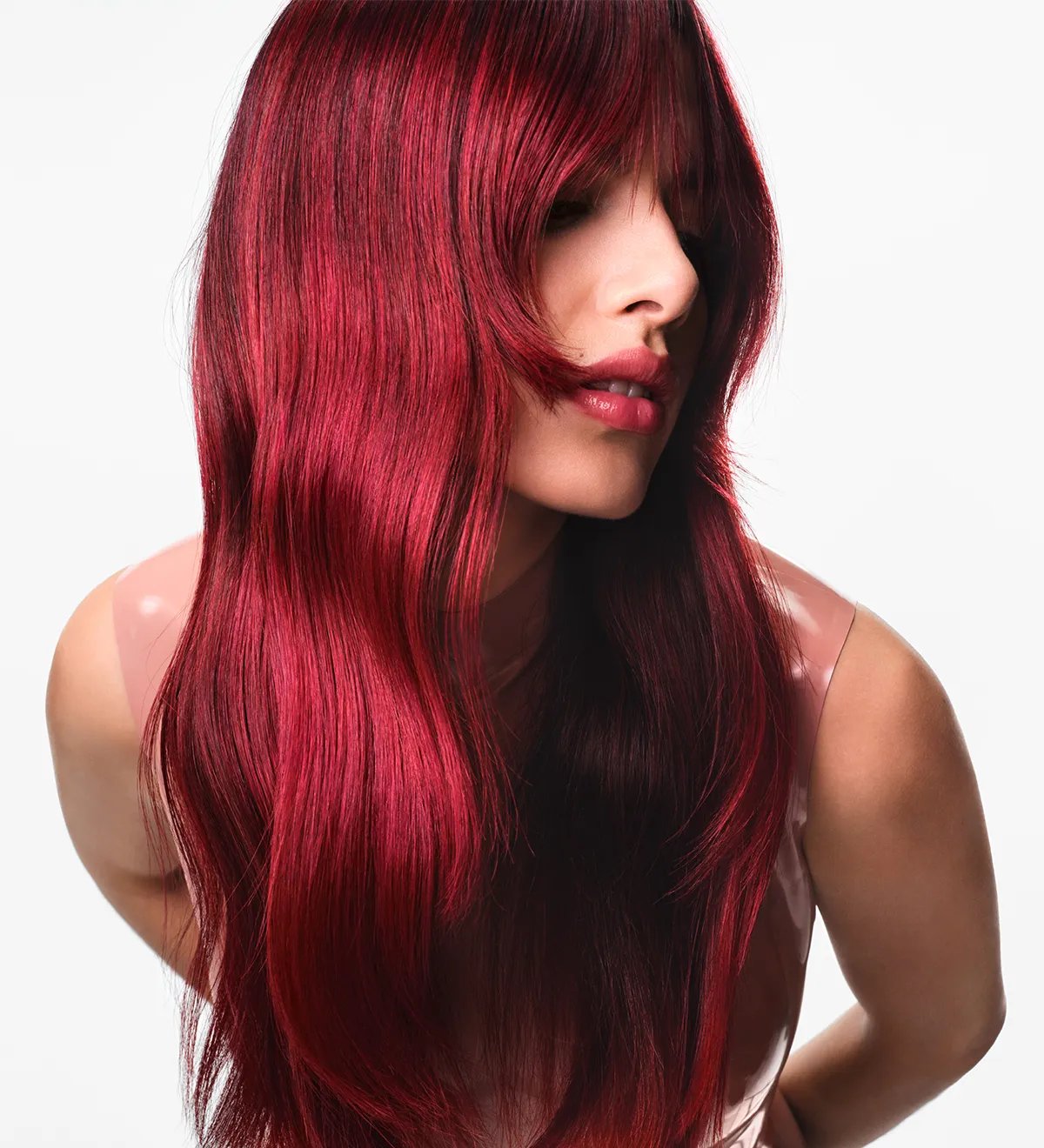 Model with long, wavy, red hair and bottleneck bangs.