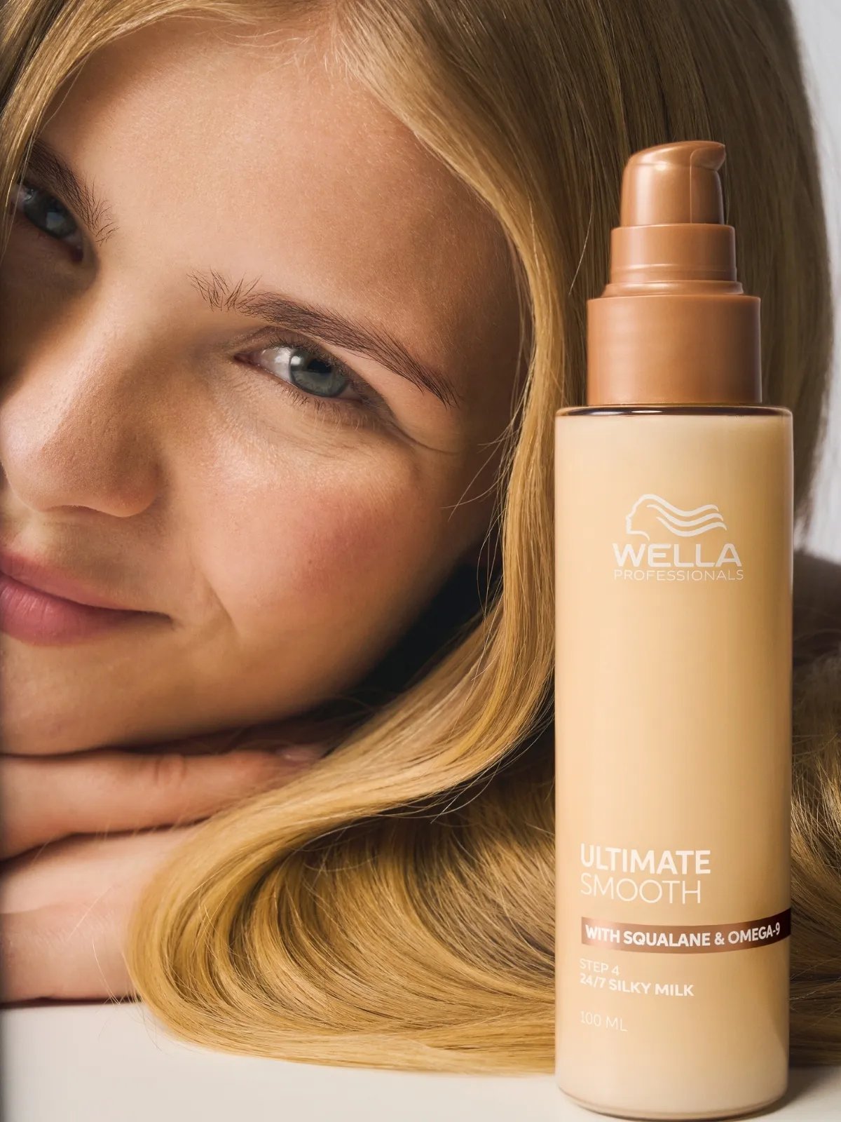 Blonde model poses next to ULTIMATE SMOOTH Silky Milk.