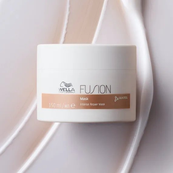 Model holds open jar of Fusion Intense Repair Mask.