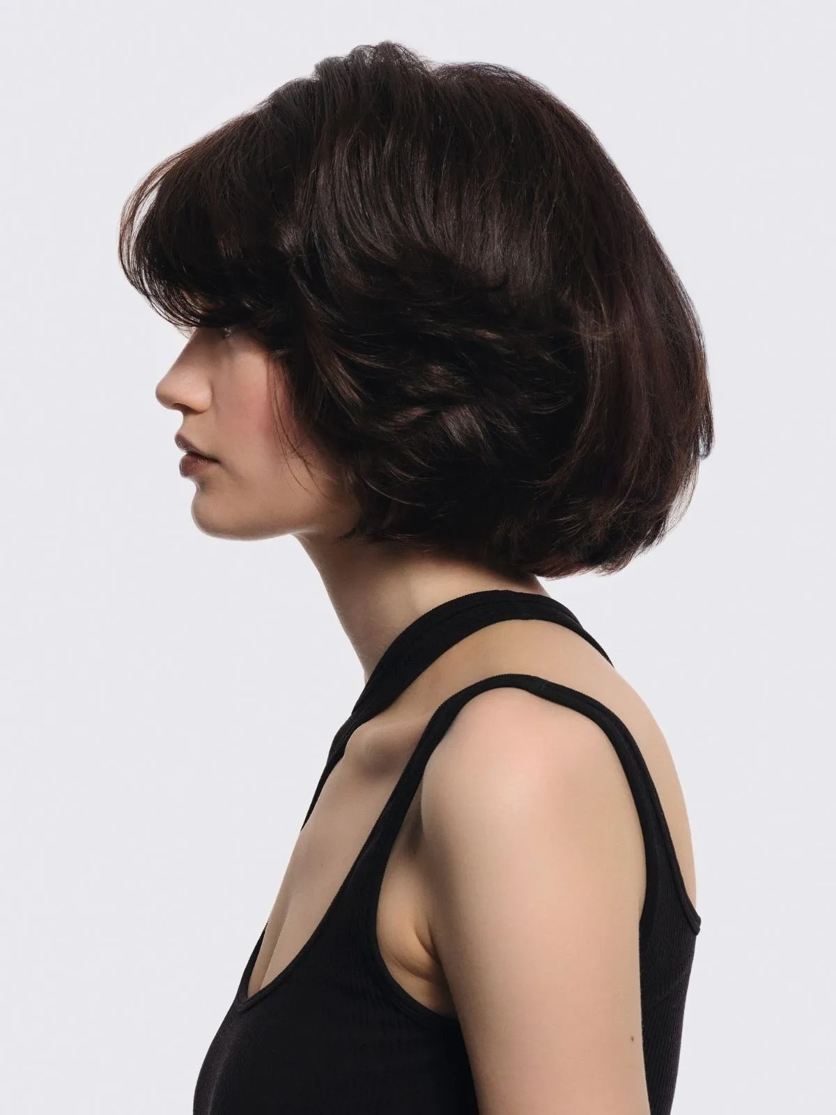 Model with darker, glossier, brunette bob after a Supernatural Color service.