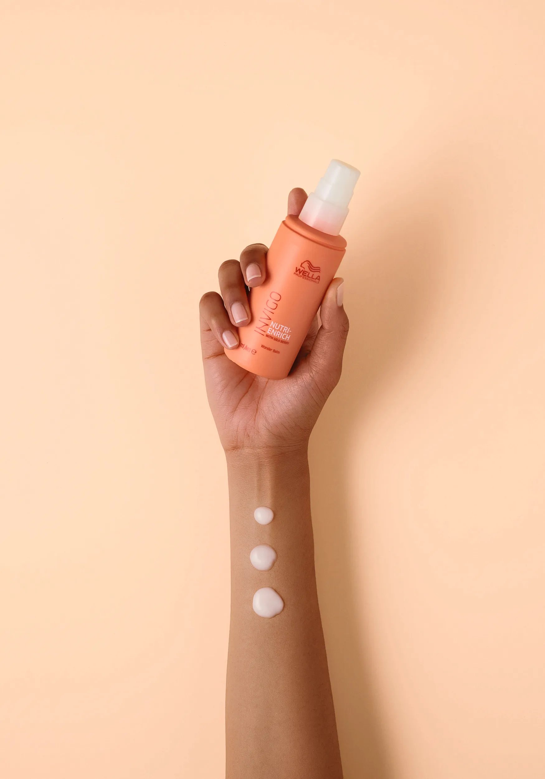 Hand holding Nutri-Enrich Wonder Balm, with swatches showing how much to use. 