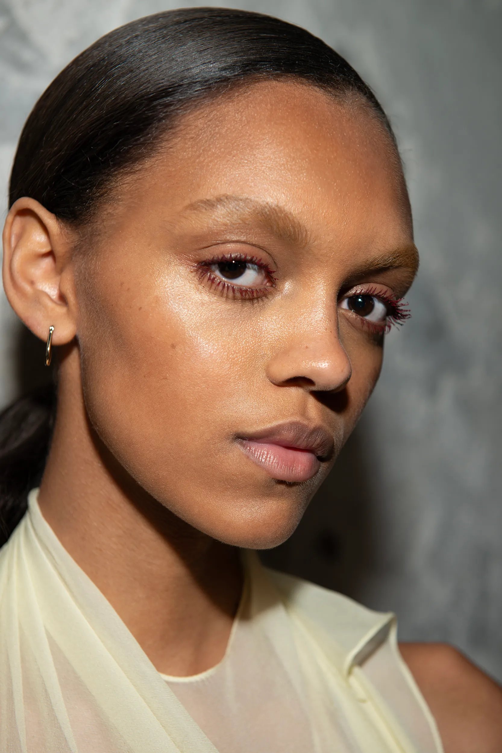 A model with a sleek side ponytail looking at the camera