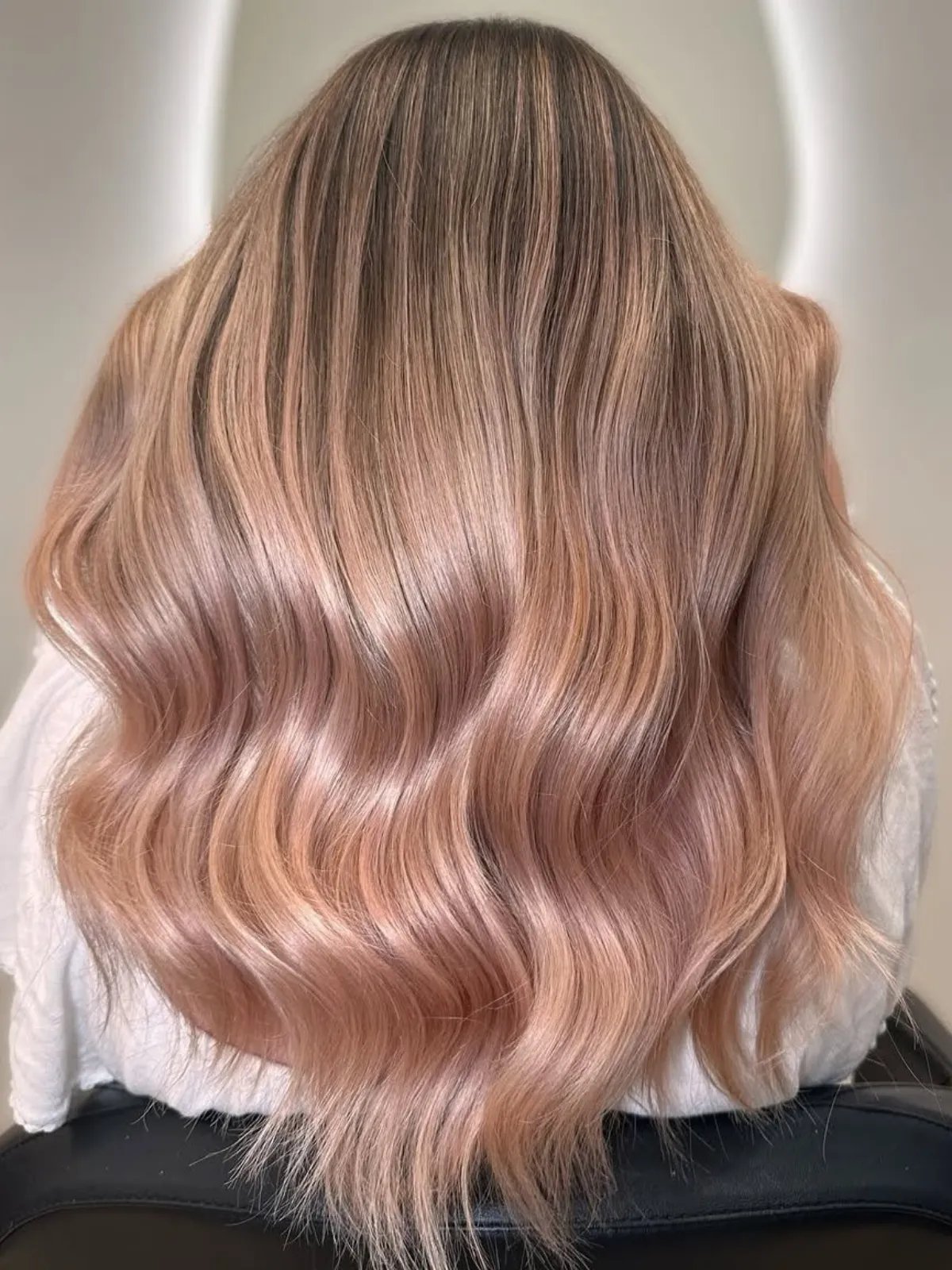 Model with long, neutral blonde hair featuring a subtle blush pink glow.