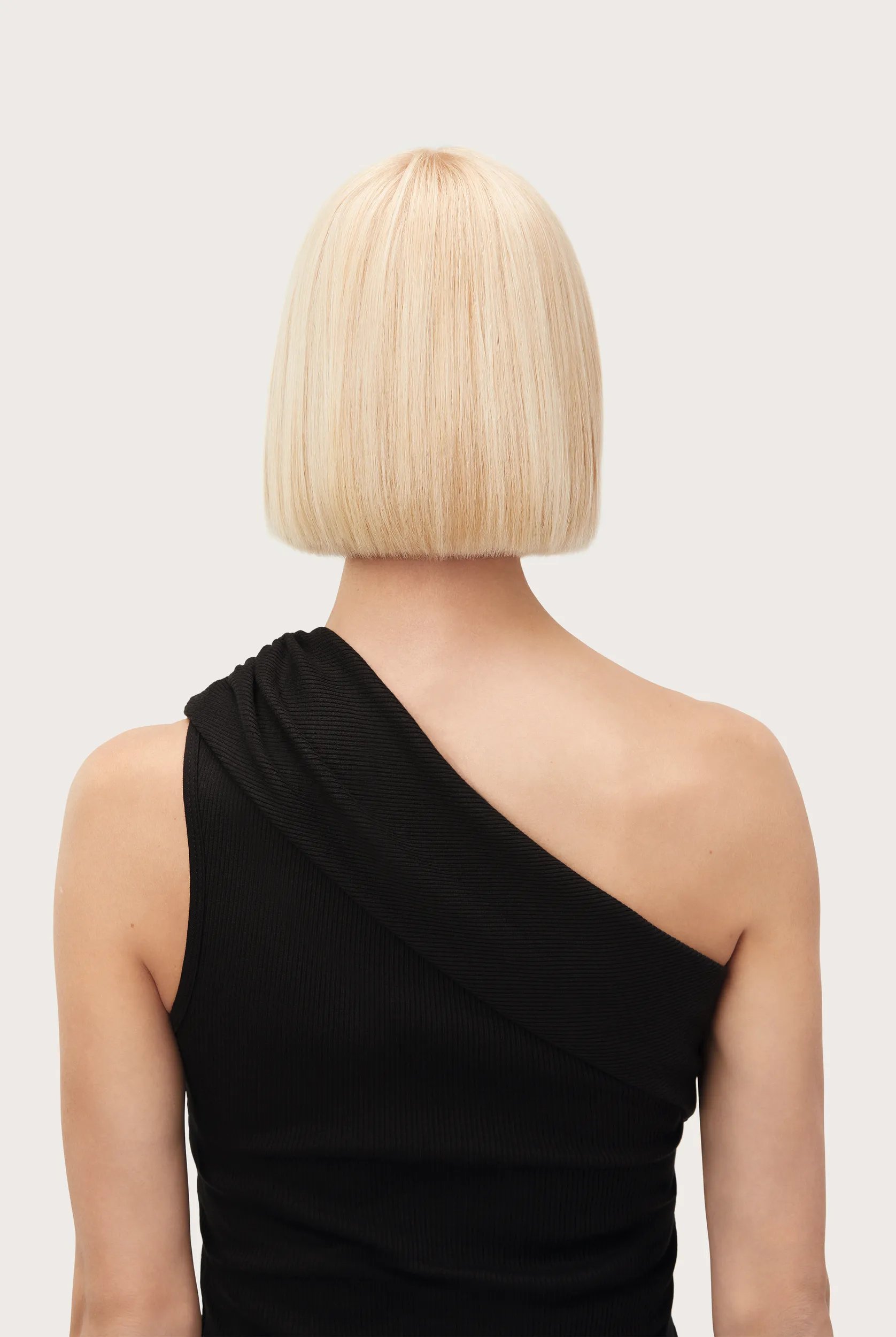 Model with short blonde bob faces away from the camera. Hair looks fresh, healthy and the brassy tones shown in the before image are gone. 