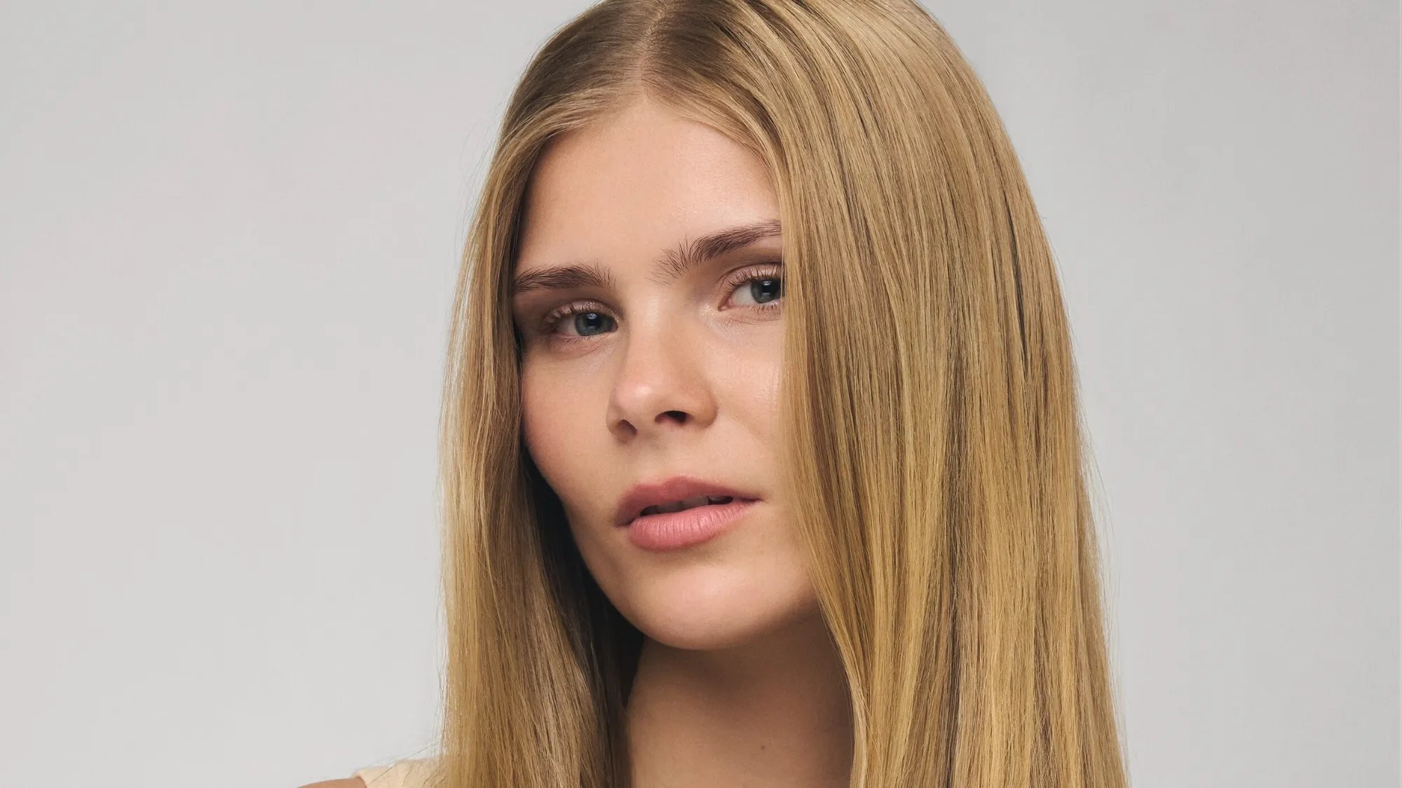 Model with ultra-smooth, straight, butter blonde hair.