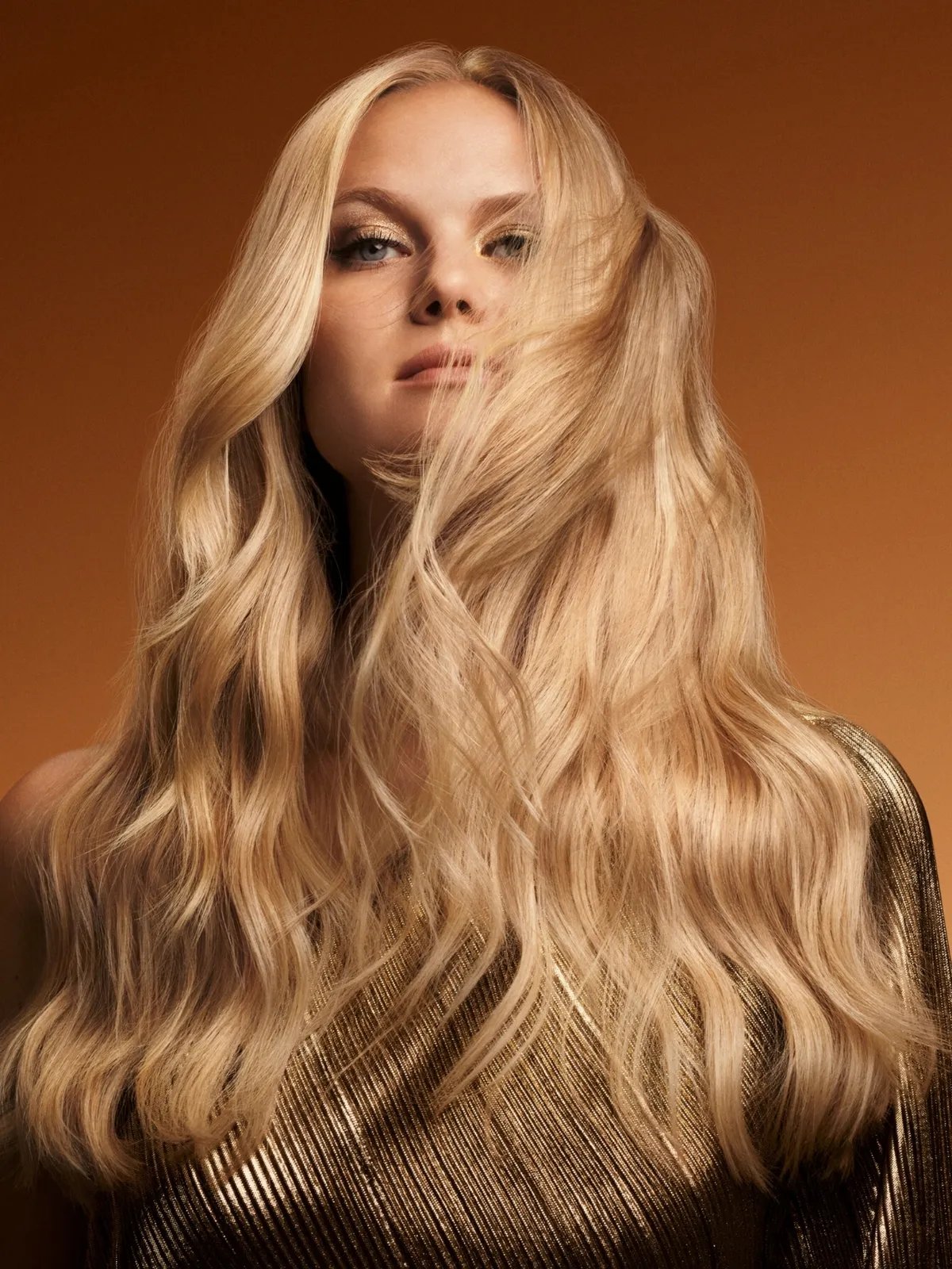 Model with ultra-long, golden blonde hair that appears shiny after using ULTIMATE SMOOTH.