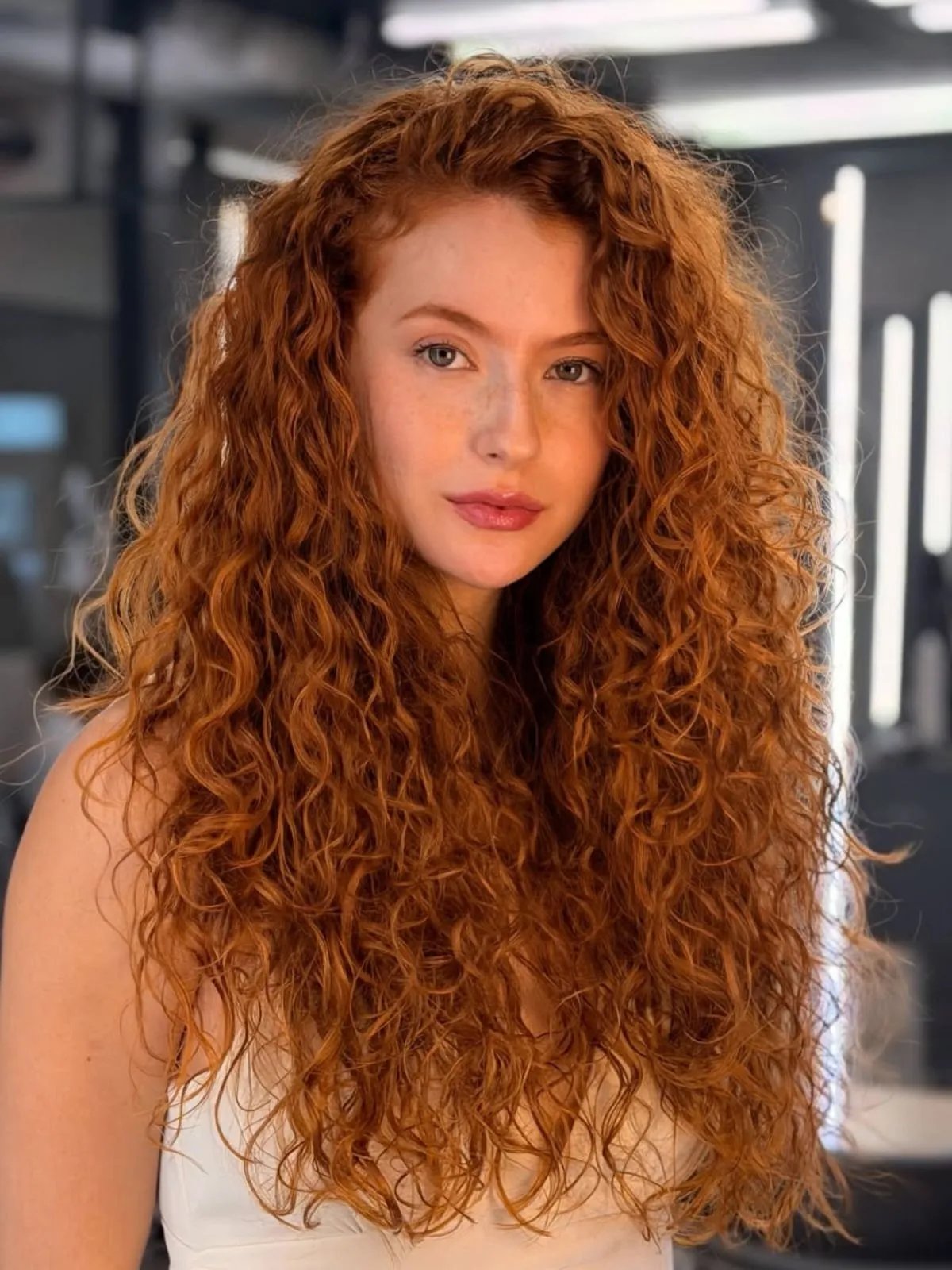 Model with long, curly, copper red hair.