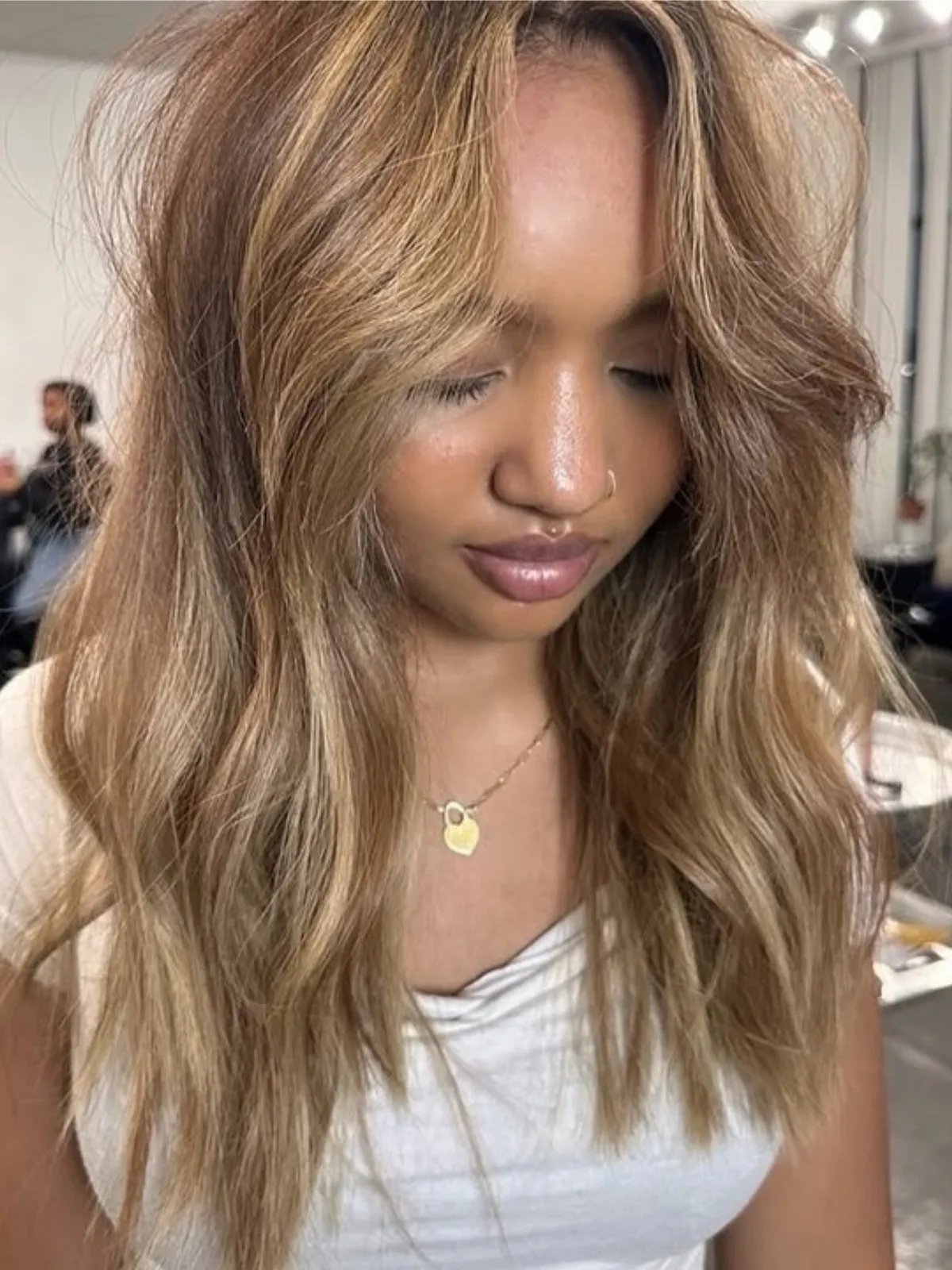 Model with chocolate brown hair color featuring brown-blonde highlights.