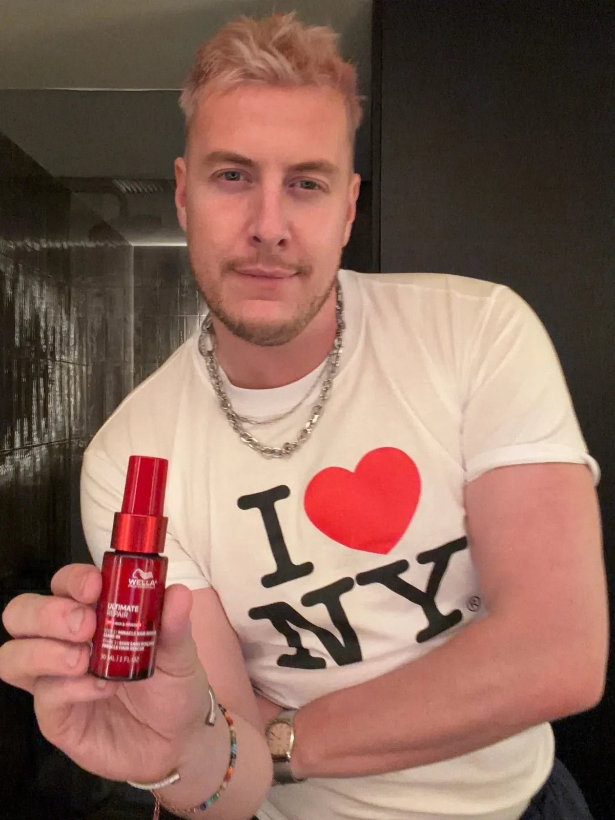 Wella Professionals Global Ambassador James Earnshaw holds a bottle of ULTIMATE REPAIR Miracle Hair Rescue.