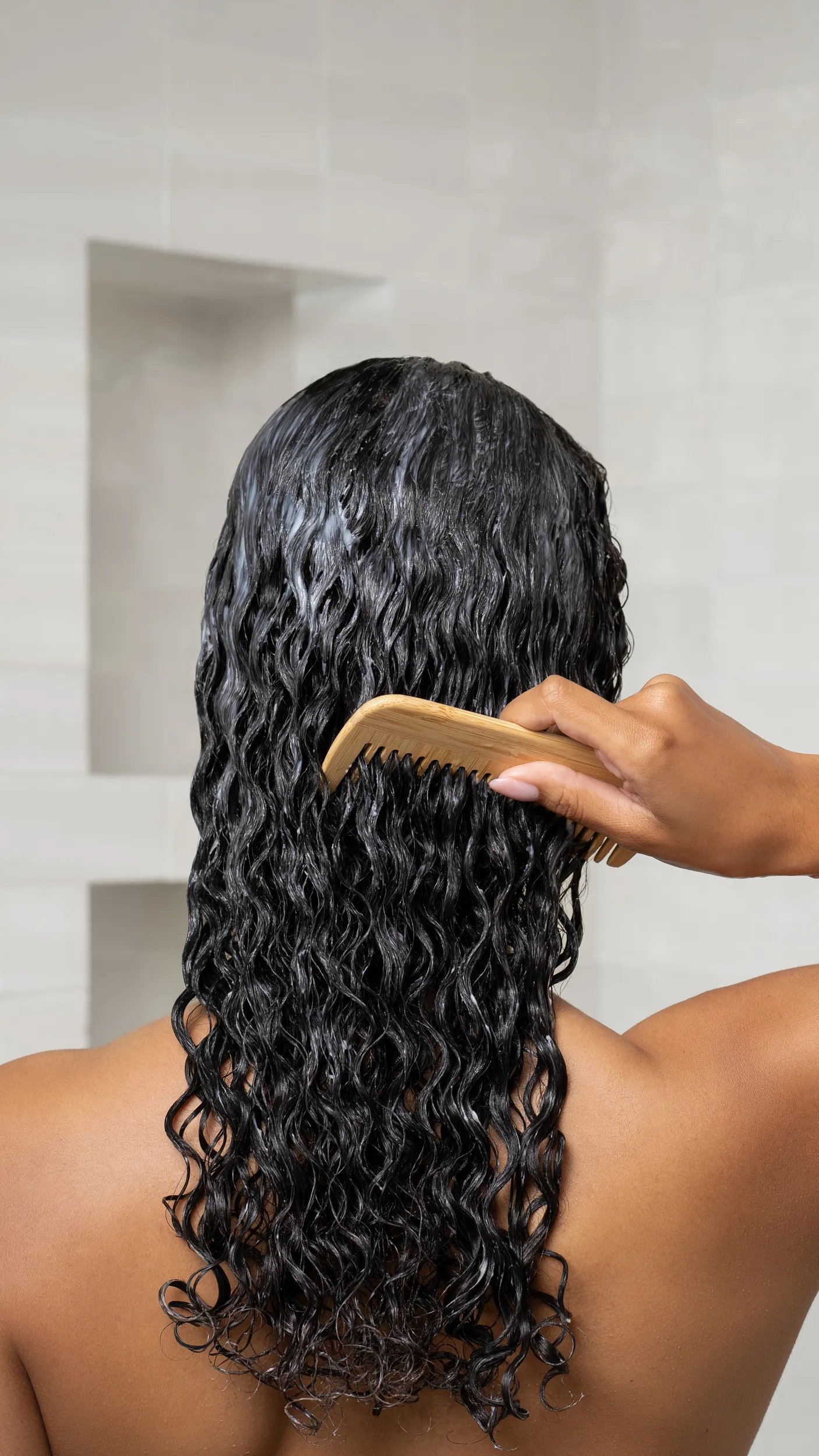 Before and after showing model’s long, curly, dark hair appearing shinier and more defined after using ULTIMATE SMOOTH.