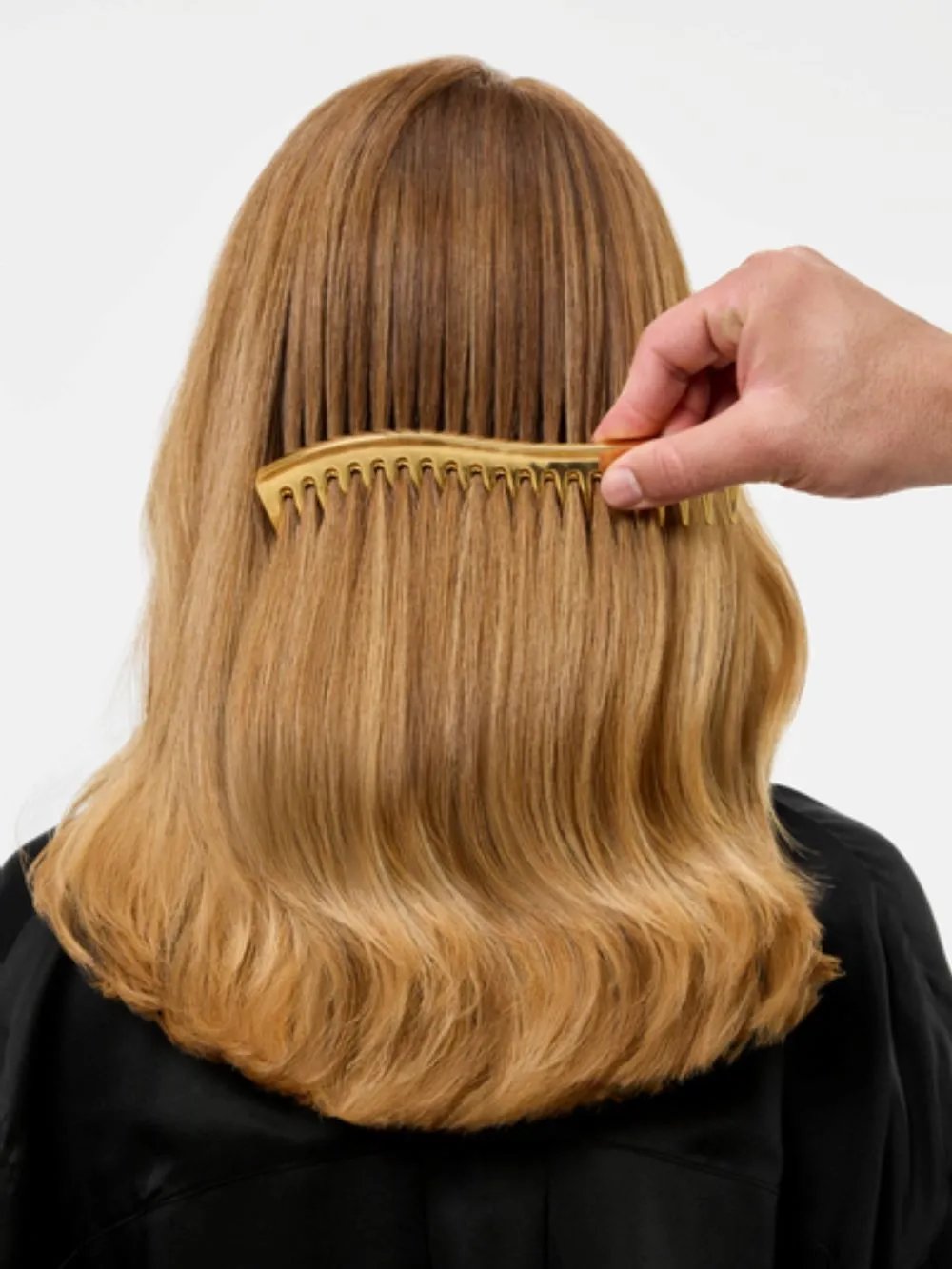 Stylist combing through the model’s hair.