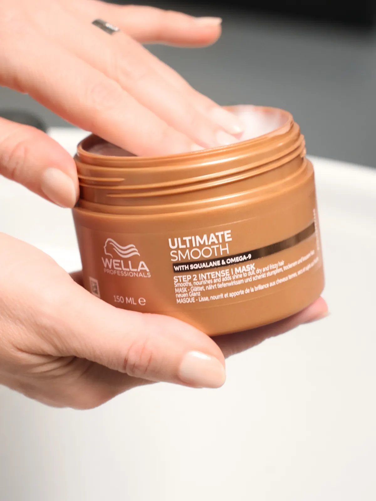 Model scoops ULTIMATE SMOOTH Mask out of the jar. 