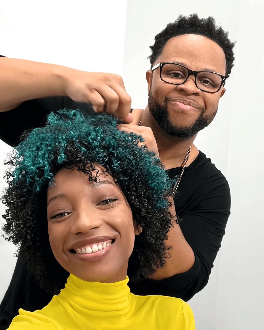 A hairdresser styles a model’s hair.