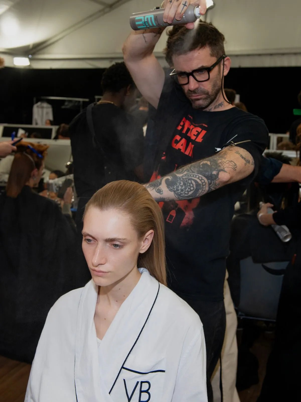 Anthony Turner styles a model’s blonde hair with EIMI Perfect Setting spray