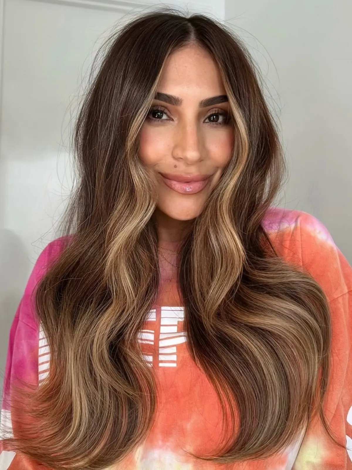 Model with brown hair featuring dark blonde face-framing highlights.