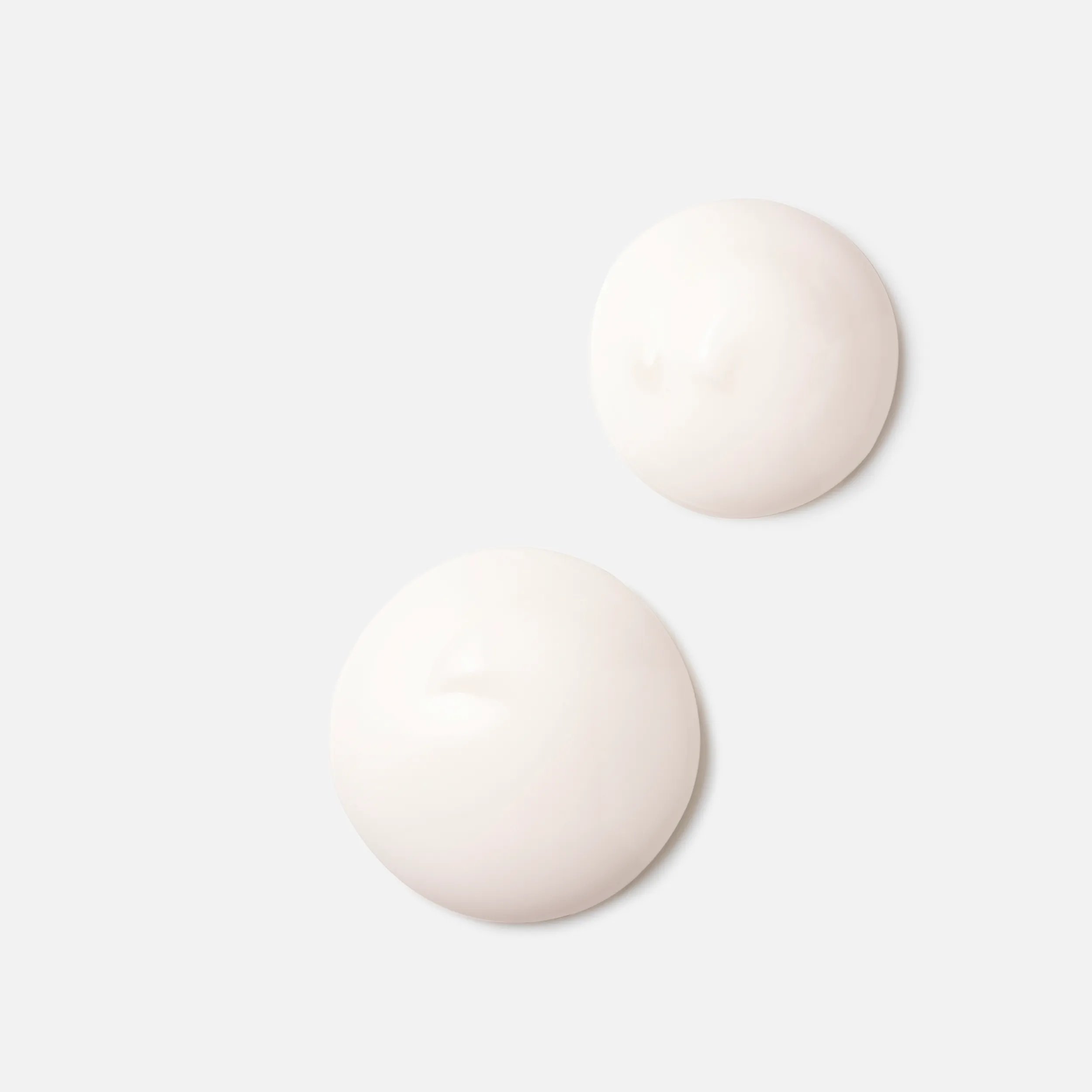 Close-up photograph of a circular blob of Invigo Nutri-Enrich Frizz Control Cream on a white background, with text saying 'oleic acid & panthenol, help to provide moisturization & nourishment'.