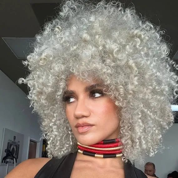 Model with curly, silver platinum blonde hair.