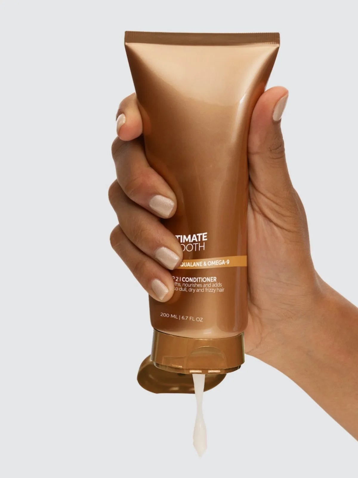 Model squeezes ULTIMATE SMOOTH Conditioner from the tube.
