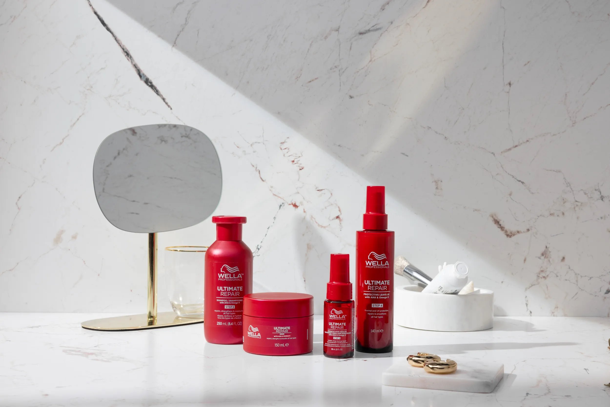 ULTIMATE REPAIR collection including Shampoo, Mask, Miracle Hair Rescue and Protective Leave-In on a marble surface.