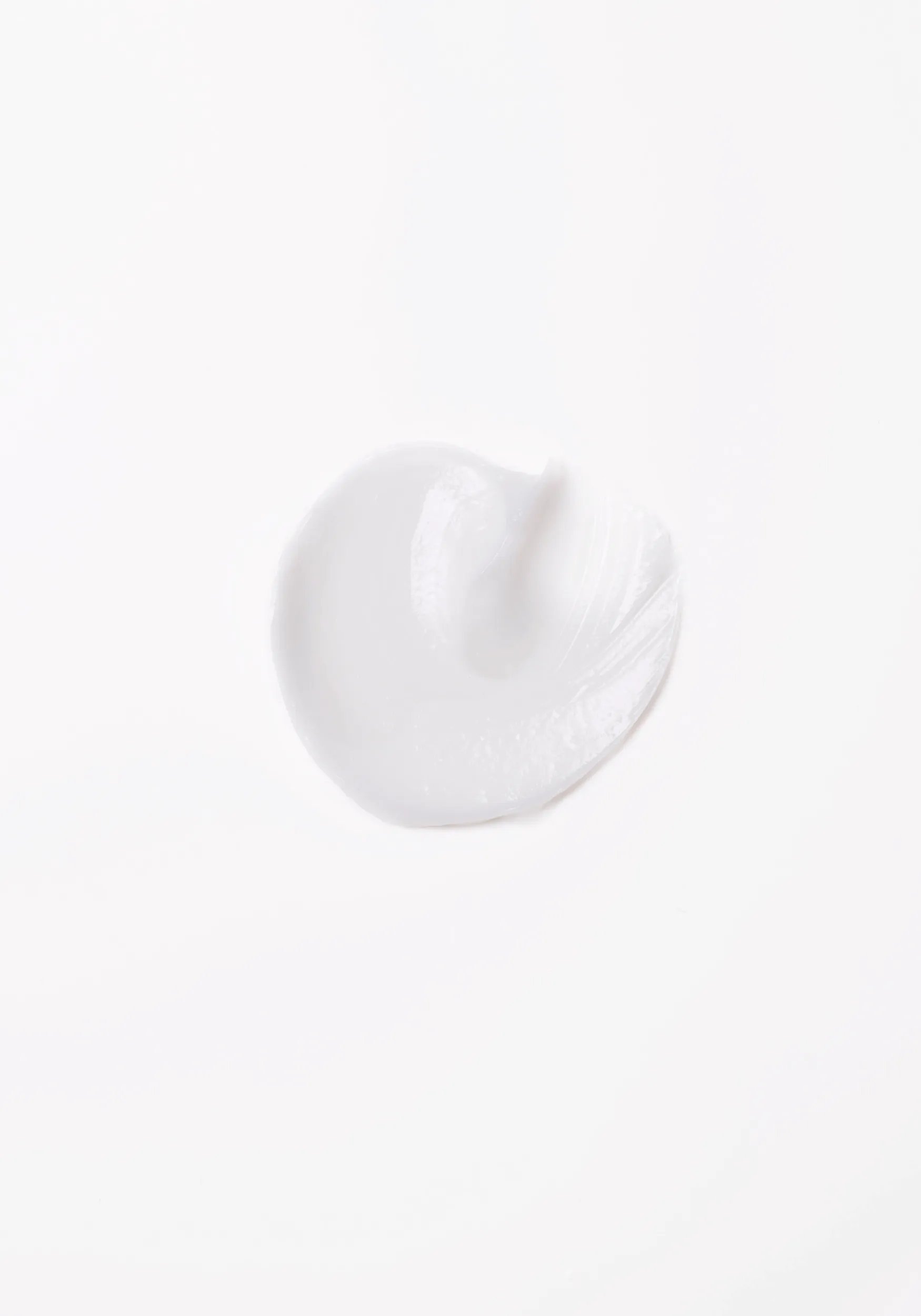Close-up photograph of a circular blob of Invigo Brilliance product on a white background, with text saying 'antioxidant shield, helps control the oxidation process after coloring' and 'metal purifier, protects from harmful metals in water'.