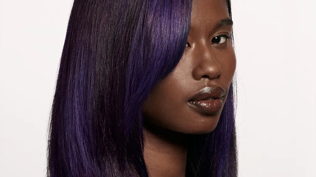 Model with dark brown and purple, relaxed hair.