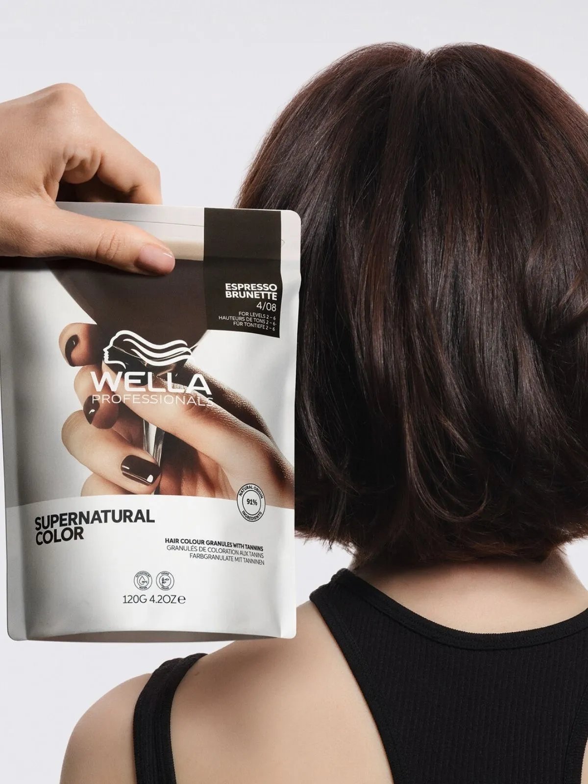 Model with short, glossy, brunette bob. Supernatural Color in Espresso Brunette is held in front of the hair.