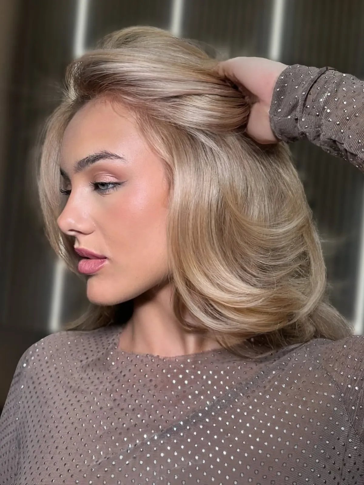 Model with golden champagne hair styled in a bouncy blow-dry.