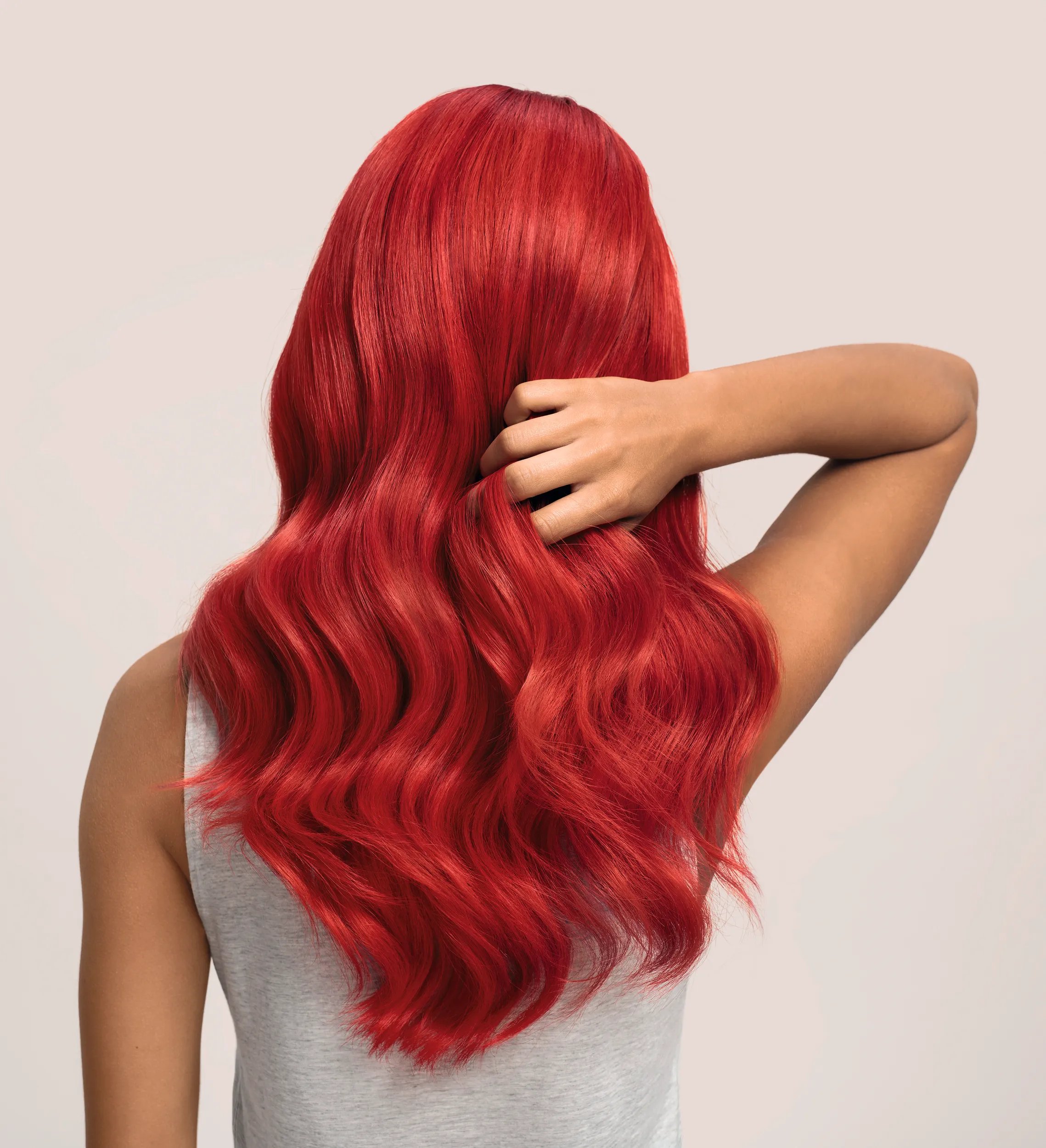Back of woman’s head with long, wavy, red hair.