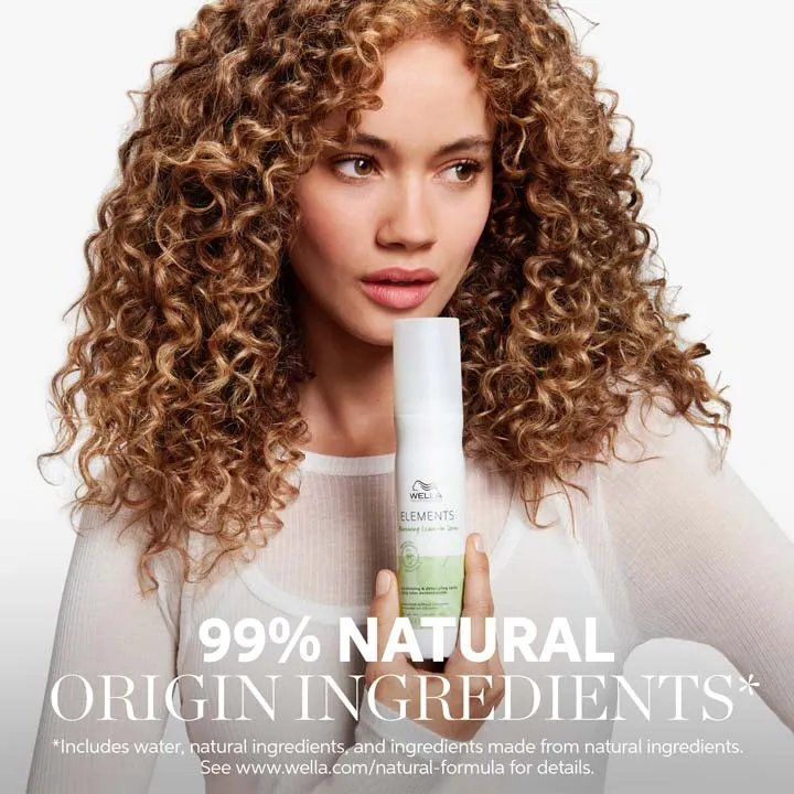 Image of a young female model with curly brown hair, with text overlaid saying '91% natural origin formula* *includes water, natural ingredients and ingredients made from natural ingredients. See www.wella.com/natural-formula for details.'
