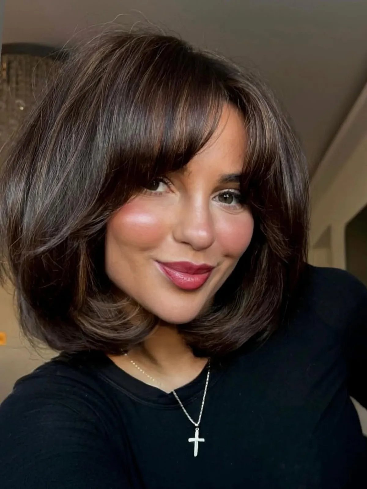 Model with mocha brown bob haircut styled in a glossy blow-dry, showcasing smooth texture and healthy shine.