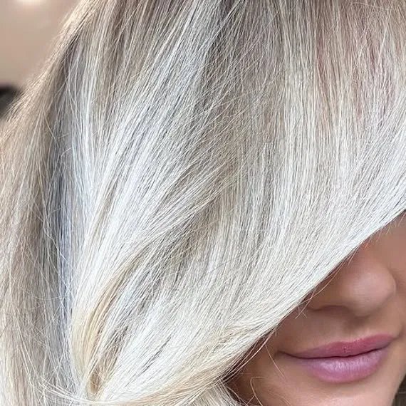 Model with rooted platinum blonde hair.