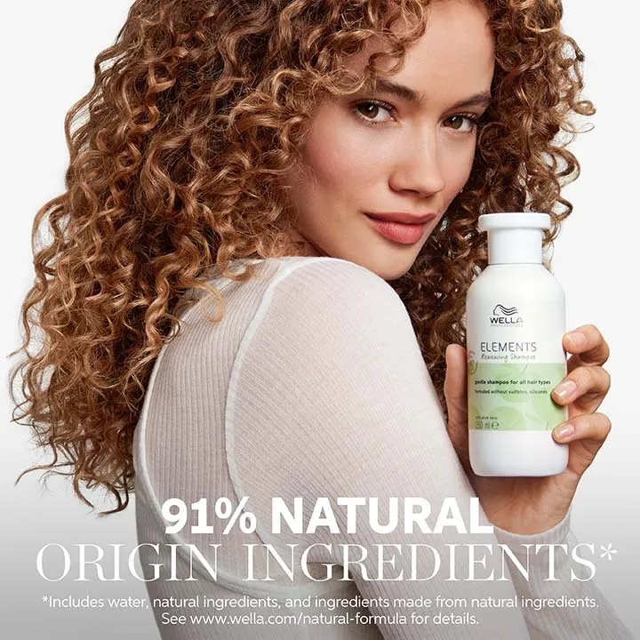 Image of a young female model with curly brown hair, with text overlaid saying '91% natural origin formula* *includes water, natural ingredients and ingredients made from natural ingredients. See www.wella.com/natural-formula for details.