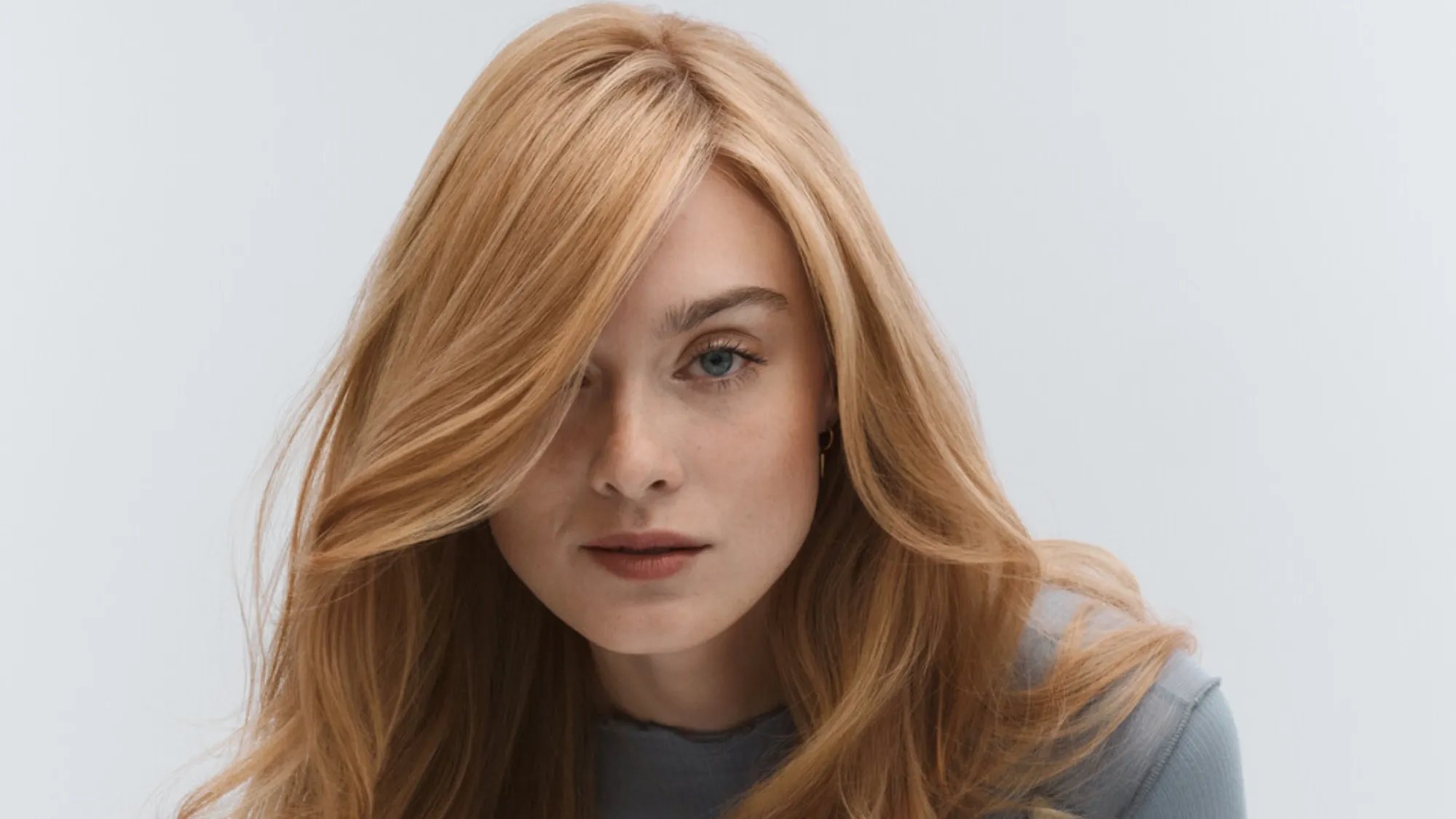 Model with long, strawberry blonde hair partially covering one eye