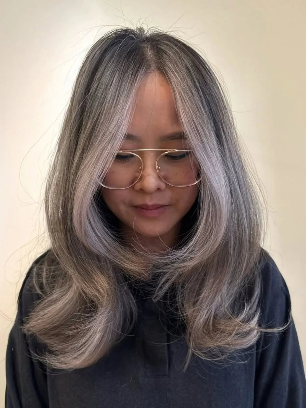 Model with dark hair featuring silvery grey highlights.