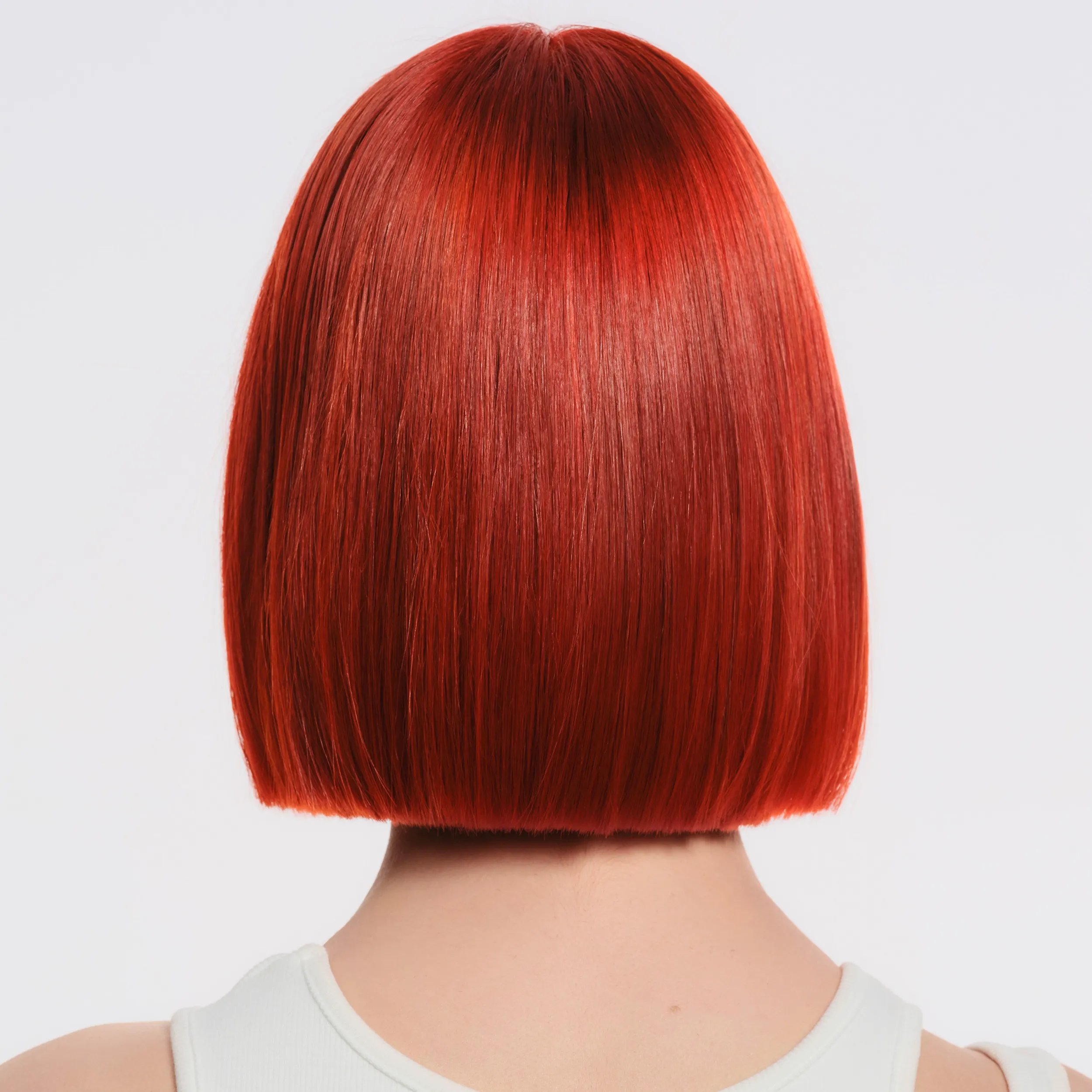 Image of the back of a model's head against a white background. Hair is short, red and straight. 	