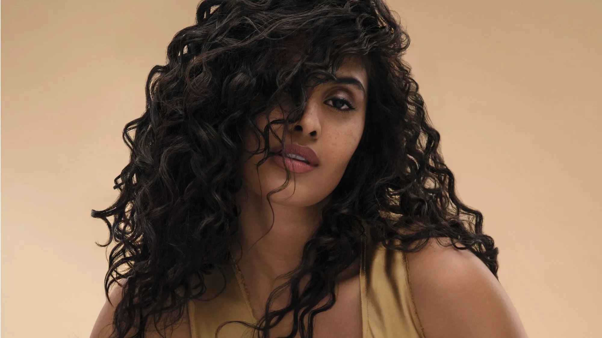 Model with smooth, bouncy, dark brown curls.