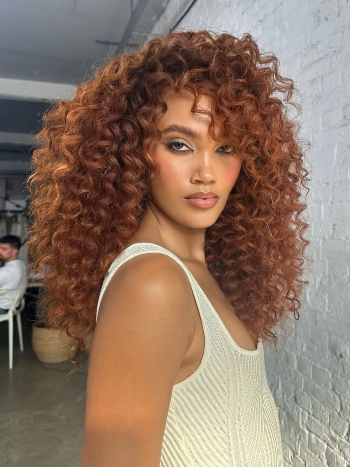 Model with long, copper brown, curly hair