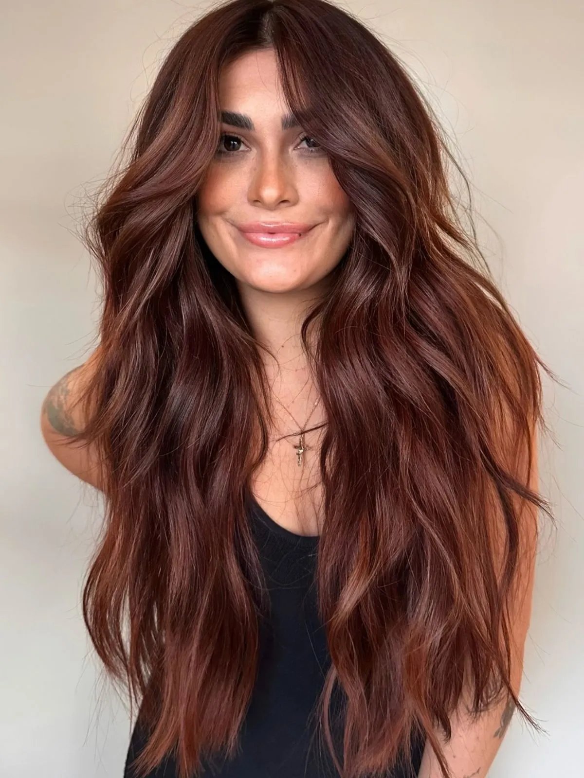 Model with ultra-long, auburn hair styled in tousled waves.