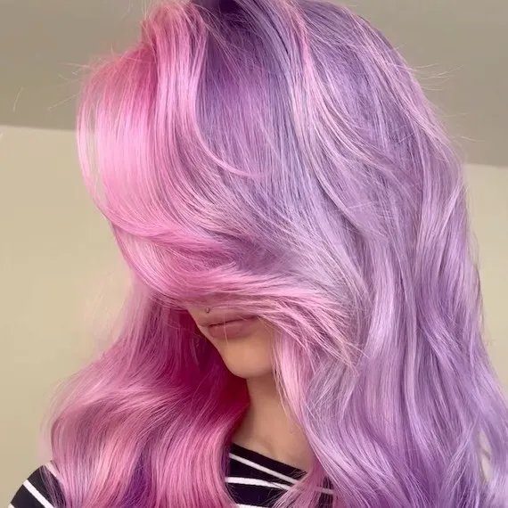 Model with long, wavy, purple hair featuring hot pink through the face frame.